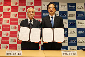 合意書にサインを交わした，石毛博行 理事長と山本修三 理事長