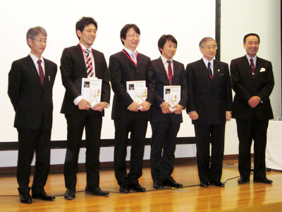 集合写真:左より,日立メディコ前田常雄執行役常務,豊田氏,高尾氏,家入氏,日本コンピュータ外科学会北島政樹理事長,第21回日本コンピュータ外科学会大会島田光夫大会長