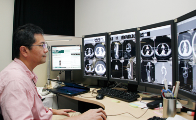 画像診断室の4面構成の端末で読影を行う放射線診断科の信澤宏部長