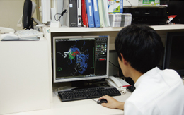 CT室のクライアントを操作する原田副主任は，マルチボリュームでの重ね合わせの精度が高いと述べる。