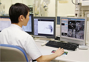 Allura Xper FD20付属のワークステーションを用いて診療放射線技師がCBCT画像から腫瘍をセグメント化し，EmboGuideを操作する。龍田俊一技師は，EmboGuideにより手技の状況を把握しやすくなったとメリットを挙げる。