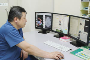 釧路脳神経外科の診察室の電子カルテシステム 診察室では3面モニタが標準となっている。同院の入江伸介院長は「現場の要望通りの使い勝手が実現されているので使いやすいシステムです」と評価する。