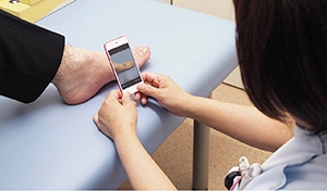 病棟でのiPod touch＋FileMaker Goの患部の撮影風景。撮影した画像はCSS経由で電子カルテに登録可能