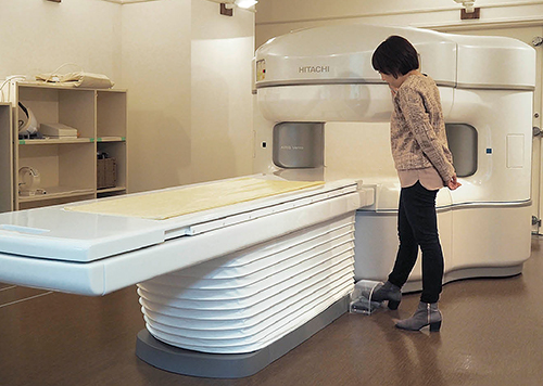もう一つのMRI室には，永久磁石型0.3TオープンMRI「AIRIS Vento」を展示。ハンズフリーで寝台操作が可能なフットスイッチ操作を体験。