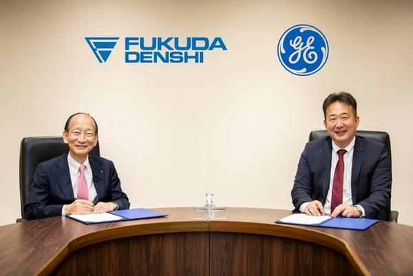 写真左 フクダ電子 代表取締役社長 白井大治郎氏，右 GEヘルスケア 代表取締役社長兼CEO 多田 荘一郎氏 （産業医の指導の下，安全な距離の確保やアクリル板の設置など感染予防に配慮して実施）