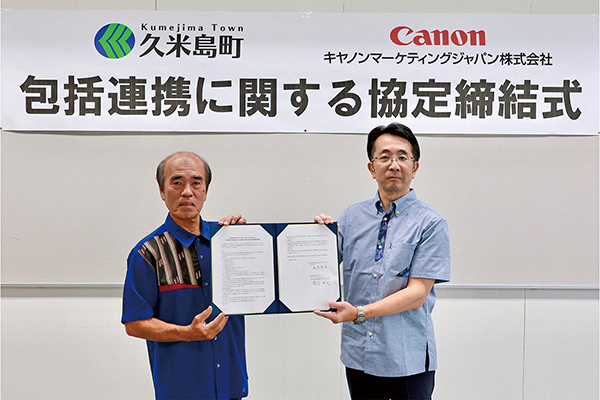 久米島町 桃原 秀雄 町長，キヤノンMJ 執行役員 常信 卓也氏（右）