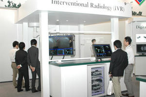 IVR手術室コントロールルームモニタ（手前右）と，手術室内の大型モニタ（左の奥）