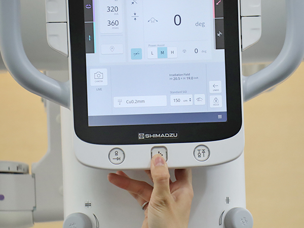 背面のハンドグリップと前面のオールフリースイッチでX線管懸垂器が高い位置にあっても容易に操作可能