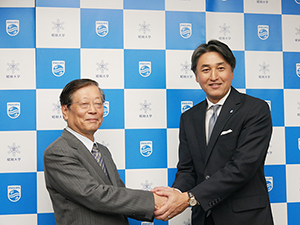 握手を交わす小口勝司昭和大学理事長（左）と堤　浩幸フィリップス・ジャパン代表取締役社長