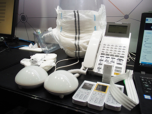 介護施設向けケア支援ソリューションのBLE受信機（ランプ：左手前）や各種センサ，電話機