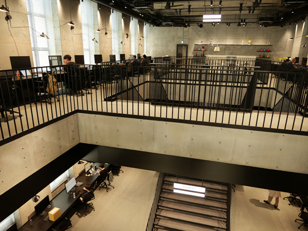 CLAY棟2階のワークスペース。吹き抜けの構造になっており，開放感と同時に中央の階段を含めて1階と2階のデザイナーのコミュニケーションを容易にする。